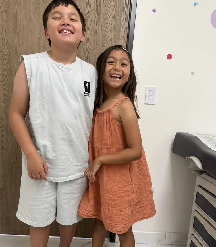 A brother and sister laughing after their checkups